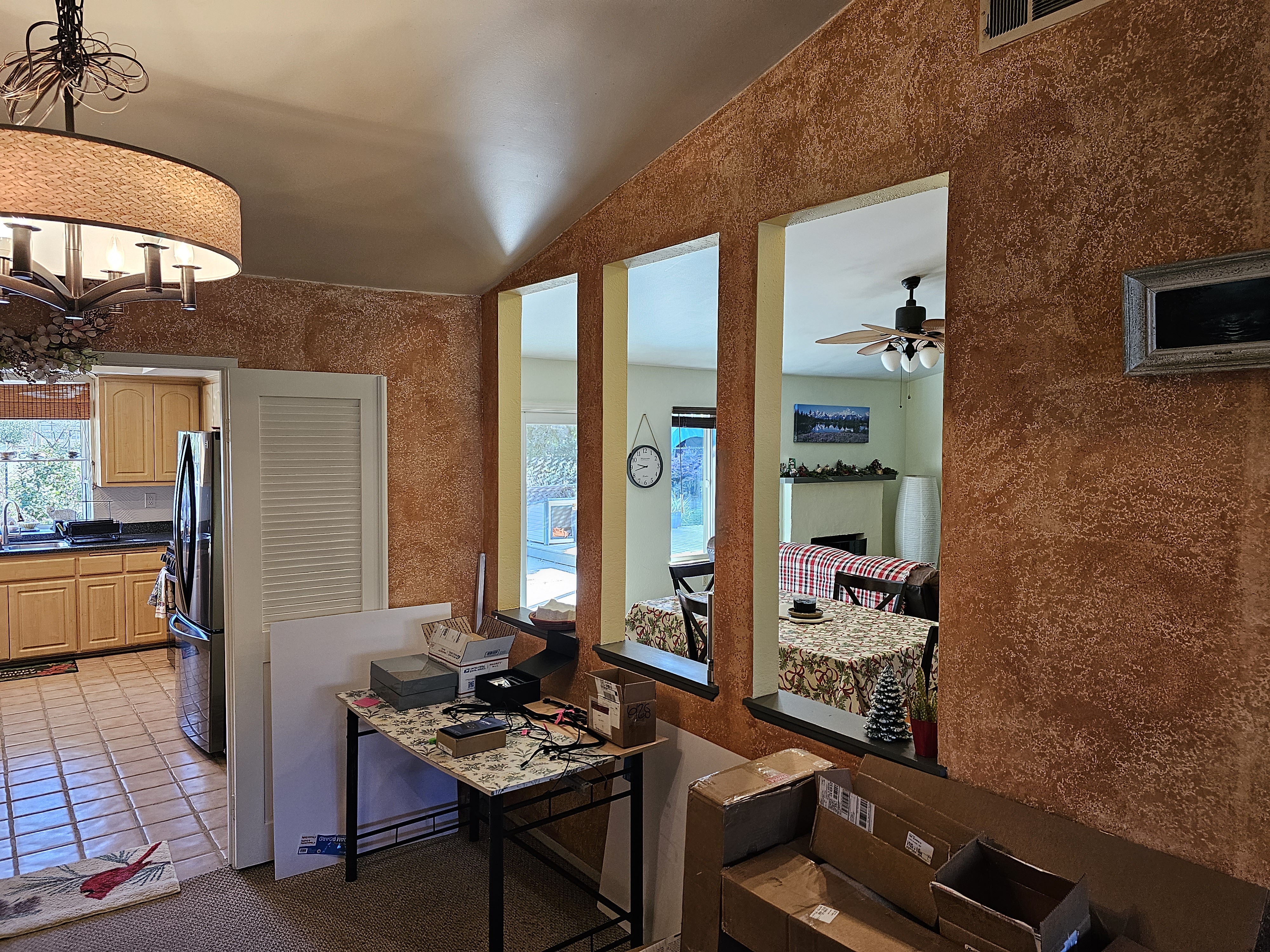 Pass-through wall from living room with brown sponge paint and dated walls